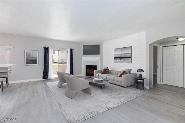 4820 Grey Wolf Ln Unit 101, Las Vegas, NV 89149 - living room featuring arched walkways, light wood-style floors, and a fireplace