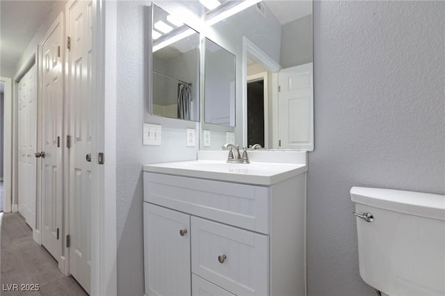 4820 Grey Wolf Ln Unit 101, Las Vegas, NV 89149 - full bathroom featuring a textured wall, vanity, and wood finished floors