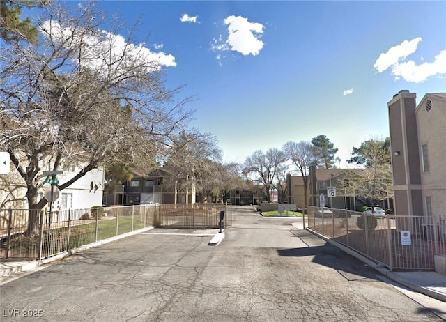 2698 Alicialynn Way, Las Vegas, NV 89121 - view of asphalt street featuring traffic signs, a residential view, a gated entry, a gate, and curbs