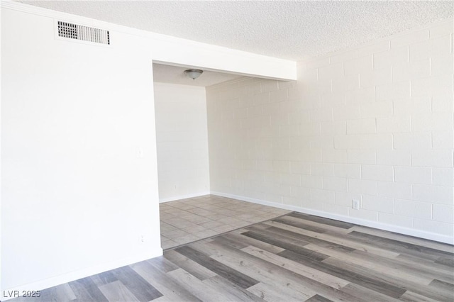 605 S Royal Crest Cir Unit 8, Las Vegas, NV 89169 - empty room with wood finished floors, a textured ceiling, and concrete block wall