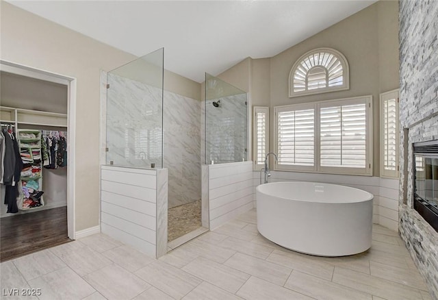 2073 Sapphire Valley Ave, Henderson, NV 89074 - bathroom with a walk in shower, a freestanding tub, a spacious closet, a fireplace, and lofted ceiling