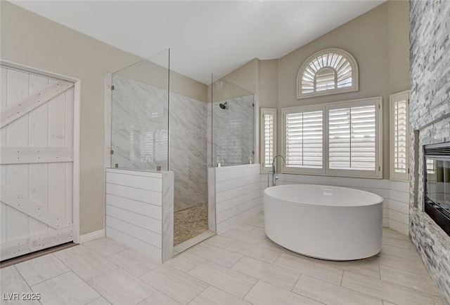2073 Sapphire Valley Ave, Henderson, NV 89074 - full bathroom with vaulted ceiling, a walk in shower, a soaking tub, and a stone fireplace