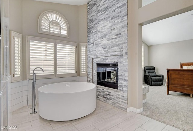 2073 Sapphire Valley Ave, Henderson, NV 89074 - full bath featuring a high ceiling, a freestanding bath, and a stone fireplace
