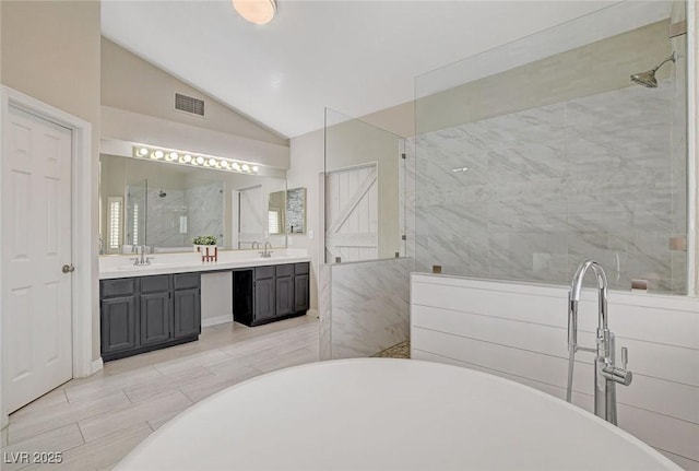 2073 Sapphire Valley Ave, Henderson, NV 89074 - bathroom featuring lofted ceiling, a walk in shower, a freestanding bath, and double vanity