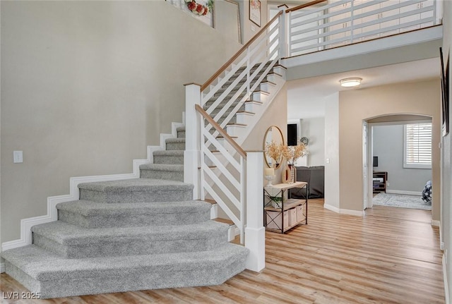2073 Sapphire Valley Ave, Henderson, NV 89074 - staircase featuring arched walkways, a high ceiling, and wood finished floors