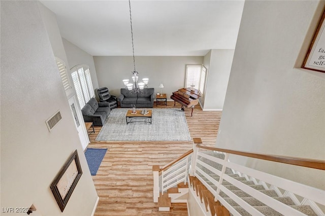 2073 Sapphire Valley Ave, Henderson, NV 89074 - living area with wood finished floors, plenty of natural light, a chandelier, and stairway