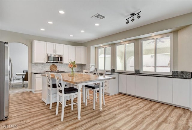 2073 Sapphire Valley Ave, Henderson, NV 89074 - kitchen featuring appliances with stainless steel finishes, light wood-style floors, recessed lighting, white cabinets, and decorative backsplash