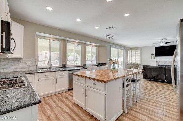 2073 Sapphire Valley Ave, Henderson, NV 89074 - kitchen featuring stainless steel appliances, wood counters, white cabinetry, open floor plan, and light wood-type flooring
