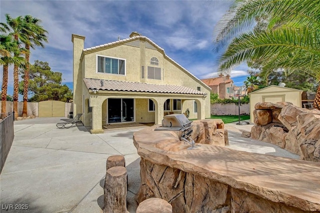 2073 Sapphire Valley Ave, Henderson, NV 89074 - rear view of property featuring exterior kitchen, stucco siding, a chimney, a patio, and a tiled roof