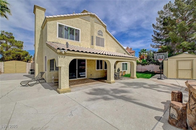 2073 Sapphire Valley Ave, Henderson, NV 89074 - rear view of property featuring a storage shed, stucco siding, a chimney, and a tiled roof