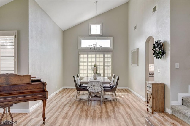 2073 Sapphire Valley Ave, Henderson, NV 89074 - dining space with high vaulted ceiling, arched walkways, light wood-type flooring, and a chandelier
