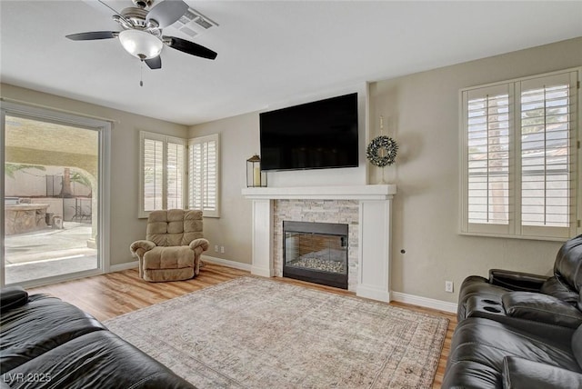 2073 Sapphire Valley Ave, Henderson, NV 89074 - living area featuring plenty of natural light, wood finished floors, and a stone fireplace