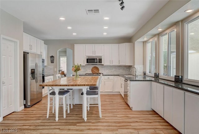2073 Sapphire Valley Ave, Henderson, NV 89074 - kitchen featuring stainless steel appliances, arched walkways, butcher block countertops, white cabinetry, and decorative backsplash