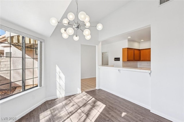 1911 Hobson Dr, Henderson, NV 89074 - unfurnished dining area with healthy amount of natural light, wood finished floors, a chandelier, and high vaulted ceiling