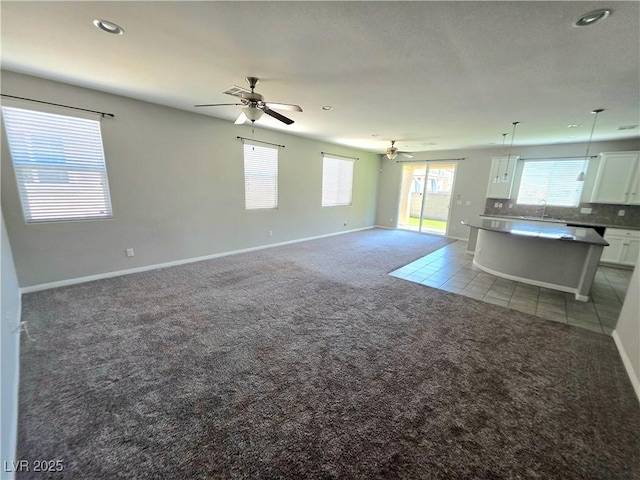 3708 Fuselier Dr, North Las Vegas, NV 89032 - unfurnished living room featuring light colored carpet, ceiling fan, recessed lighting, healthy amount of natural light, and light tile patterned floors