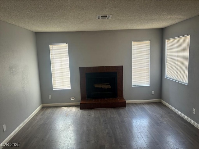 2722 Alicialynn Way, Las Vegas, NV 89121 - unfurnished living room with dark wood-type flooring, a tile fireplace, and a textured ceiling