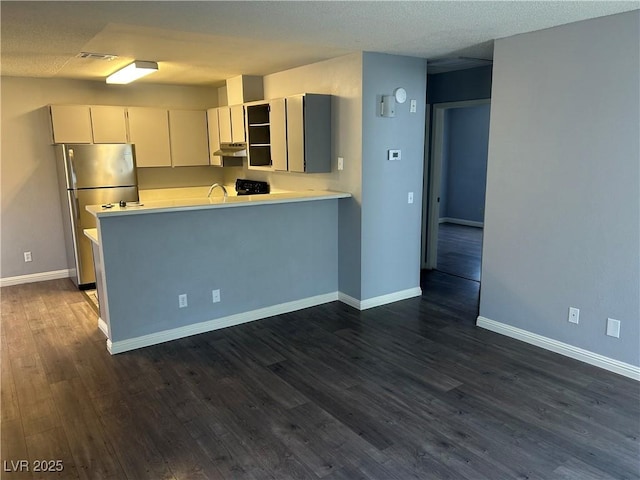 2722 Alicialynn Way, Las Vegas, NV 89121 - kitchen featuring freestanding refrigerator, under cabinet range hood, light countertops, dark wood-type flooring, and a peninsula