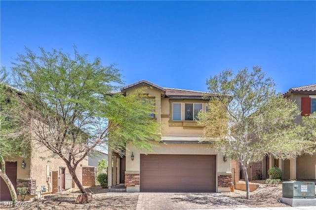 2300 Sky Island Dr, Henderson, NV 89002 - view of front of house with stucco siding, an attached garage, decorative driveway, and stone siding
