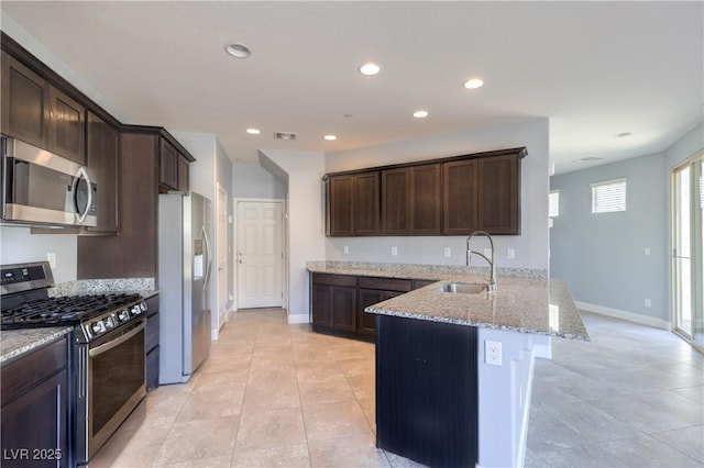 2300 Sky Island Dr, Henderson, NV 89002 - kitchen with appliances with stainless steel finishes, a peninsula, dark brown cabinets, light stone countertops, and recessed lighting
