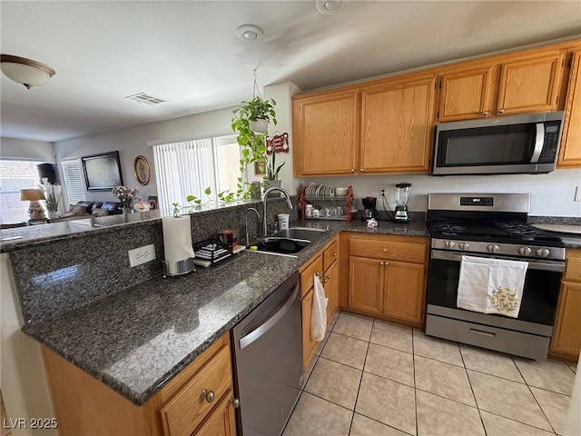 8898 Promised Land Ave, Las Vegas, NV 89148 - kitchen featuring stainless steel appliances, a peninsula, plenty of natural light, and light tile patterned floors