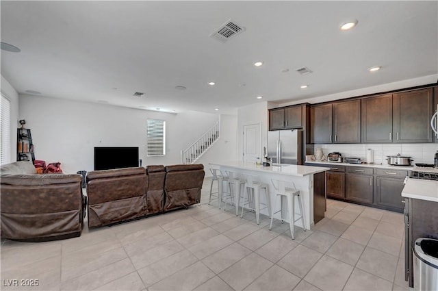 7853 Bethel Heights Ln, Las Vegas, NV 89113 - kitchen featuring open floor plan, freestanding refrigerator, a kitchen bar, dark brown cabinets, and recessed lighting