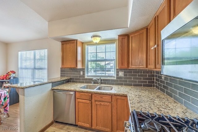 520 Arrowhead Trl Unit 522, Henderson, NV 89015 - kitchen featuring appliances with stainless steel finishes, backsplash, light stone countertops, and brown cabinets