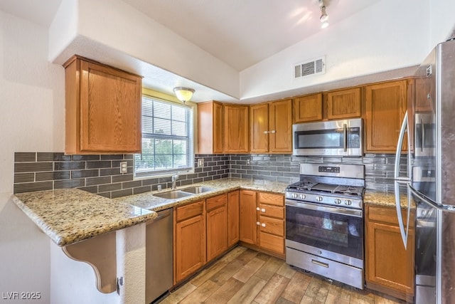 520 Arrowhead Trl Unit 522, Henderson, NV 89015 - kitchen featuring stainless steel appliances, light wood finished floors, light stone countertops, and vaulted ceiling
