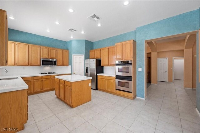 745 Diamond Bend Ave, Las Vegas, NV 89123 - kitchen featuring appliances with stainless steel finishes, light countertops, a kitchen island, recessed lighting, and arched walkways