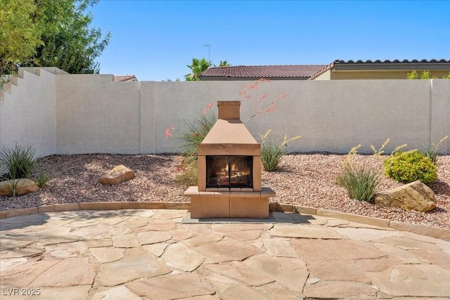 745 Diamond Bend Ave, Las Vegas, NV 89123 - fenced backyard featuring a warm lit fireplace and a patio area