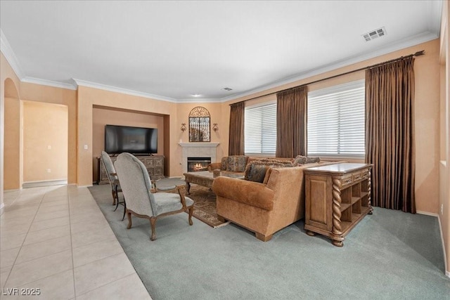 745 Diamond Bend Ave, Las Vegas, NV 89123 - living room featuring crown molding, a glass covered fireplace, light tile patterned floors, and light colored carpet