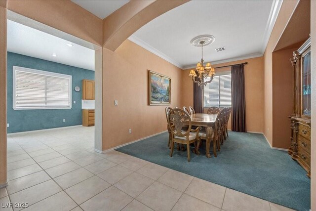 745 Diamond Bend Ave, Las Vegas, NV 89123 - dining area featuring a chandelier, crown molding, light colored carpet, arched walkways, and light tile patterned flooring