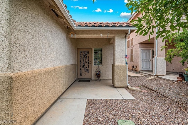 8853 Kingswood Dr, Las Vegas, NV 89147 - entrance to property featuring stucco siding, a tile roof, and a patio