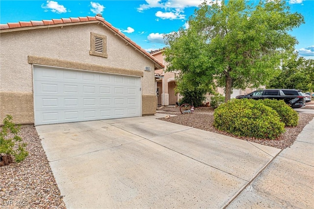 8853 Kingswood Dr, Las Vegas, NV 89147 - view of front facade with stucco siding, driveway, a tiled roof, and an attached garage