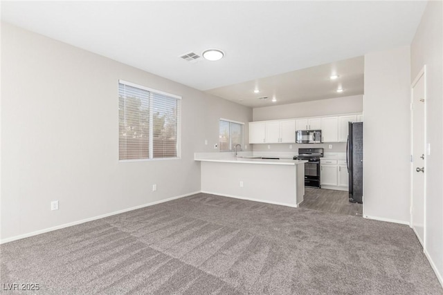 5402 Shady Lair Ct, North Las Vegas, NV 89031 - kitchen with black appliances, open floor plan, carpet floors, white cabinets, and light countertops