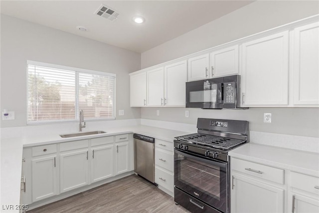 5402 Shady Lair Ct, North Las Vegas, NV 89031 - kitchen featuring black appliances, white cabinets, light countertops, and recessed lighting