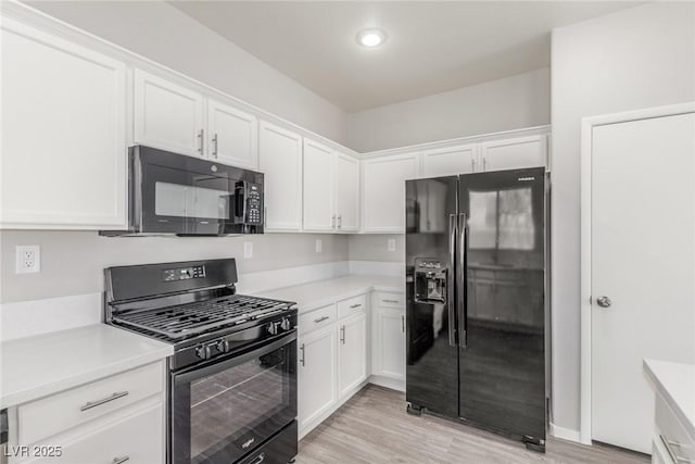 5402 Shady Lair Ct, North Las Vegas, NV 89031 - kitchen featuring black appliances, white cabinetry, light countertops, light wood-type flooring, and recessed lighting