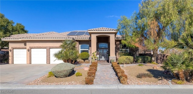 5193 N Miller Ln, Las Vegas, NV 89149 - view of front facade with stucco siding, solar panels, an attached garage, a tiled roof, and concrete driveway