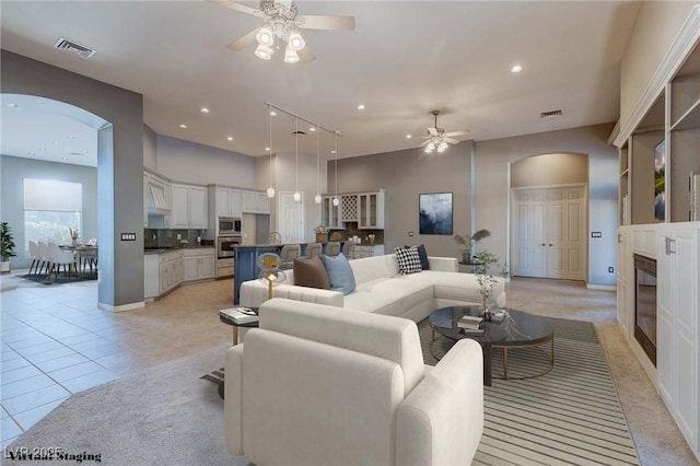 5193 N Miller Ln, Las Vegas, NV 89149 - living area featuring arched walkways, ceiling fan, a glass covered fireplace, recessed lighting, and light tile patterned flooring