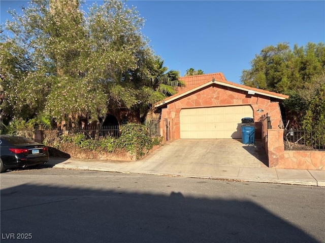 3167 El Cedro Cir, Las Vegas, NV 89121 - view of front of home featuring concrete driveway, an attached garage, and stone siding
