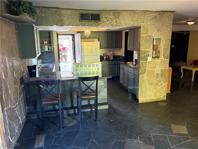 3167 El Cedro Cir, Las Vegas, NV 89121 - kitchen featuring fridge, dark countertops, and dark stone finish floors