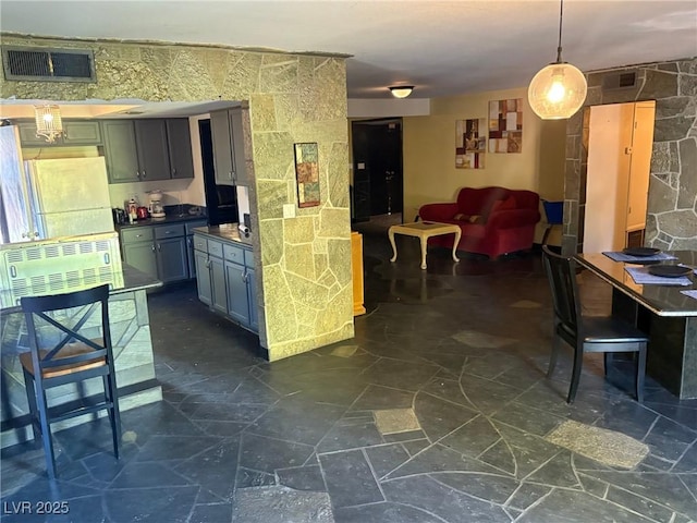3167 El Cedro Cir, Las Vegas, NV 89121 - kitchen featuring white fridge, dark countertops, open floor plan, and decorative light fixtures