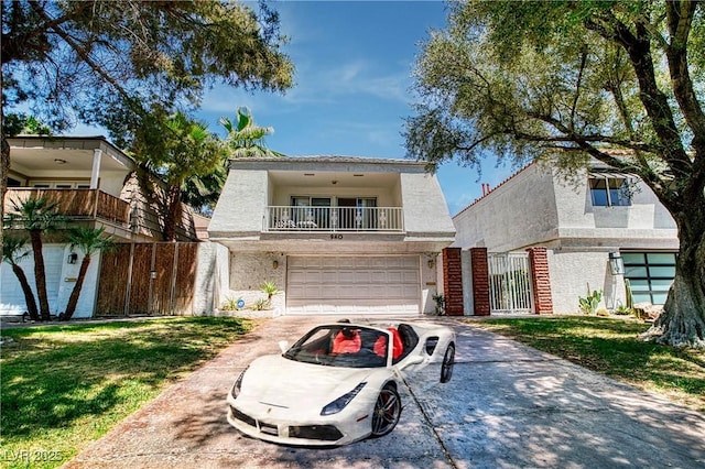 940 Vegas Valley Dr, Las Vegas, NV 89109 - view of front of home with driveway, a balcony, a garage, and stucco siding