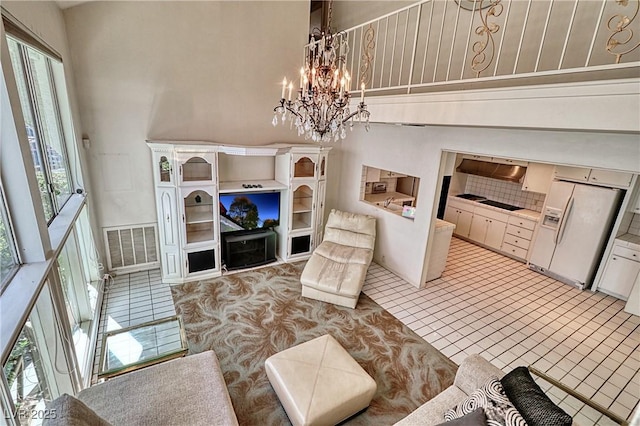 940 Vegas Valley Dr, Las Vegas, NV 89109 - living room featuring a chandelier, a towering ceiling, and light tile patterned floors
