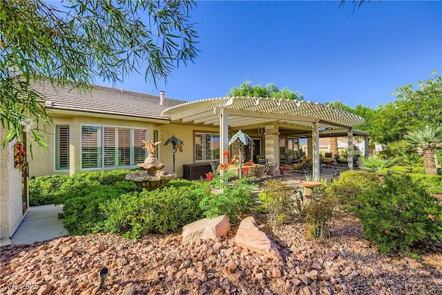 1897 Holdenville St, Henderson, NV 89052 - back of house with a pergola, stucco siding, a tiled roof, and a patio
