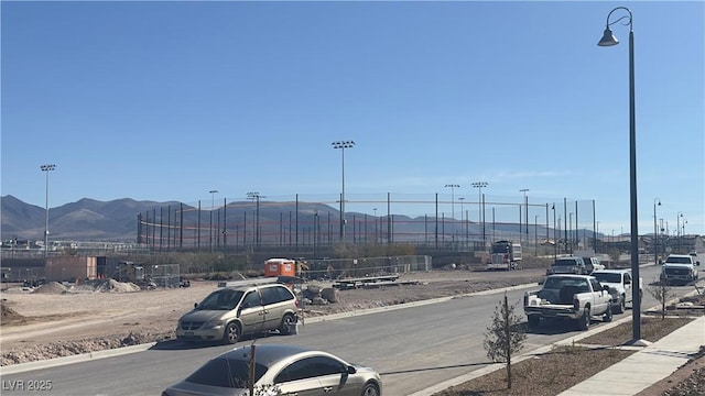 2713 Abrantes Pl, Henderson, NV 89044 - view of asphalt road with curbs, a mountain view, and street lighting