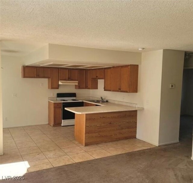 4300 N Lamont St Unit 232, Las Vegas, NV 89115 - kitchen with white range with electric stovetop, brown cabinets, under cabinet range hood, a peninsula, and a textured ceiling