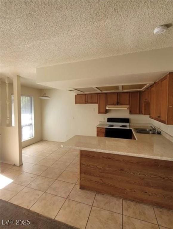 4300 N Lamont St Unit 232, Las Vegas, NV 89115 - kitchen featuring electric stove, a peninsula, brown cabinets, light tile patterned floors, and a textured ceiling