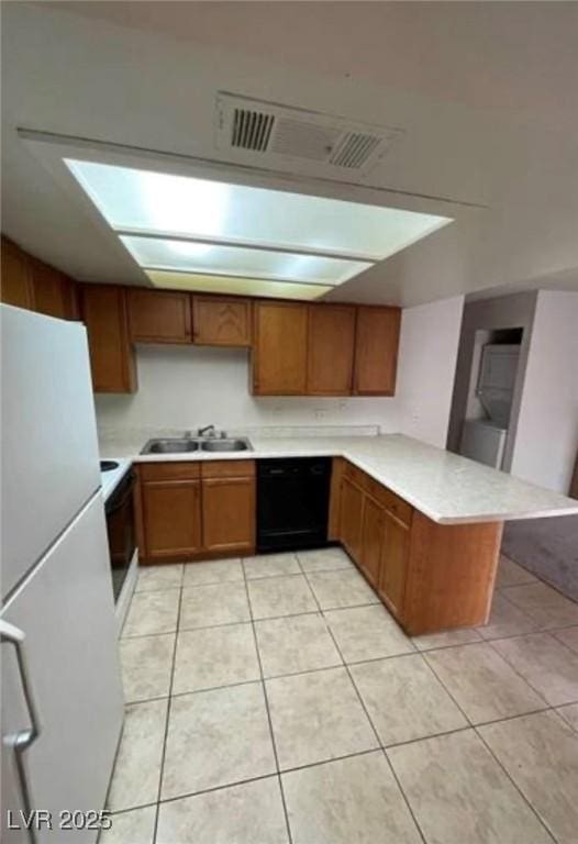 4300 N Lamont St Unit 232, Las Vegas, NV 89115 - kitchen with freestanding refrigerator, dishwasher, a peninsula, brown cabinetry, and light countertops