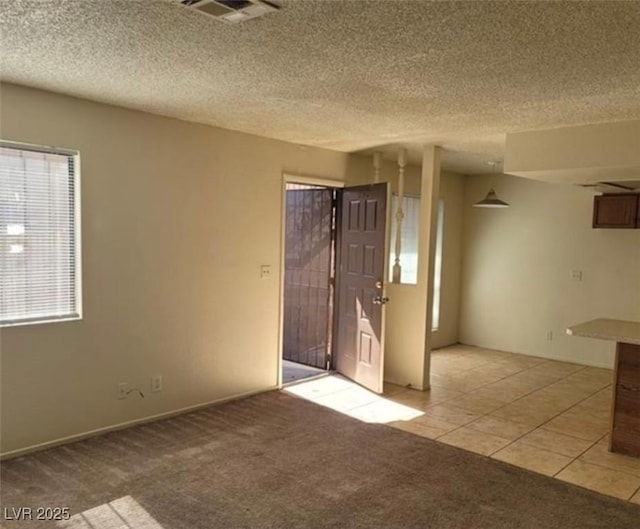 4300 N Lamont St Unit 232, Las Vegas, NV 89115 - unfurnished room featuring light tile patterned floors, light colored carpet, and a textured ceiling