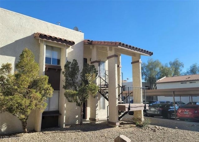 4451 Rich Dr Unit D, Las Vegas, NV 89102 - view of side of property featuring stairs, stucco siding, and a tiled roof